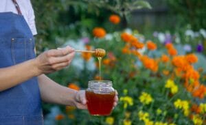 woman holding a jar of honey on a garden backgroun 2025 09 09 19 19 38 utc