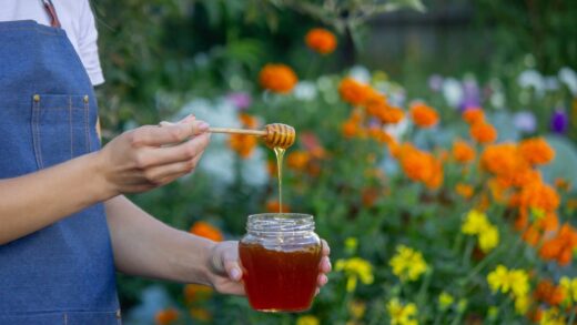 woman holding a jar of honey on a garden backgroun 2025 09 09 19 19 38 utc