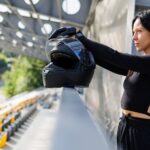 woman holding helmet at racetrack on sunny day 2026 03 10 04 49 50 utc