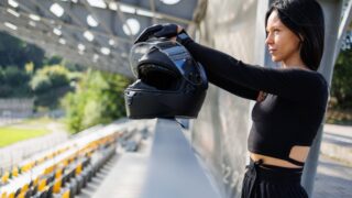 woman holding helmet at racetrack on sunny day 2026 03 10 04 49 50 utc